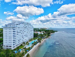 Ein Hochhaus-Hotel mit mehreren Balkonen, direkt am Strand und mit freiem Blick auf den Ozean.
