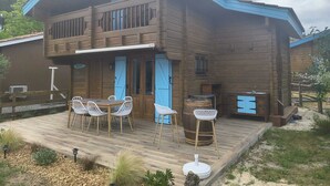 A two-story wooden house with a deck, outdoor seating, and a barbecue area. - Chalet near Mimizan in Bias in a holiday village 3KM from the ocean (Bias)