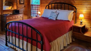 A wooden cabin bedroom with a bed, nightstand, dresser, and a window with plaid curtains. - Mountain cabin on a creek and farm, 7 miles from Smoky Mountains National Park (Townsend)