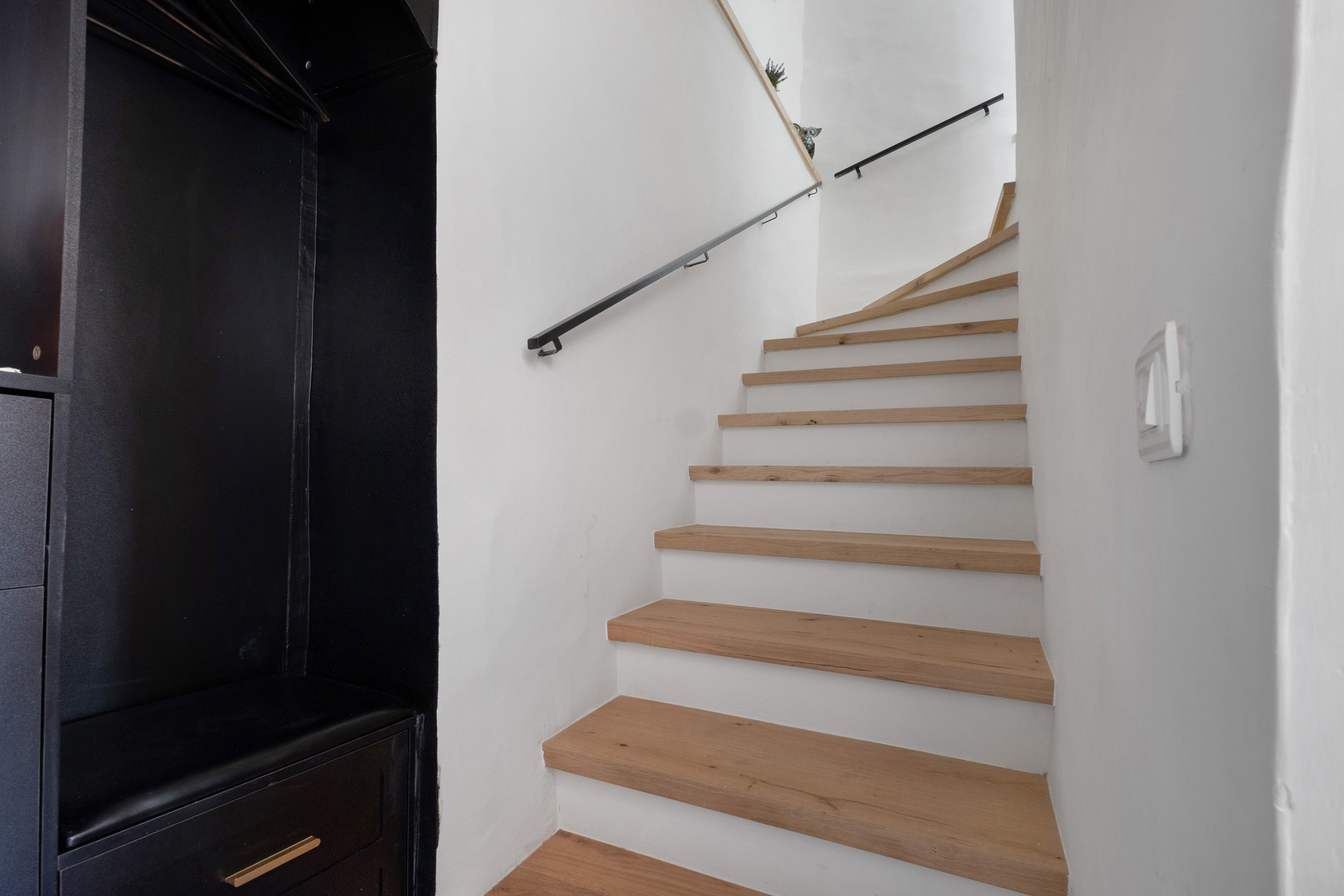 Un escalier avec des marches en bois et une rampe métallique.