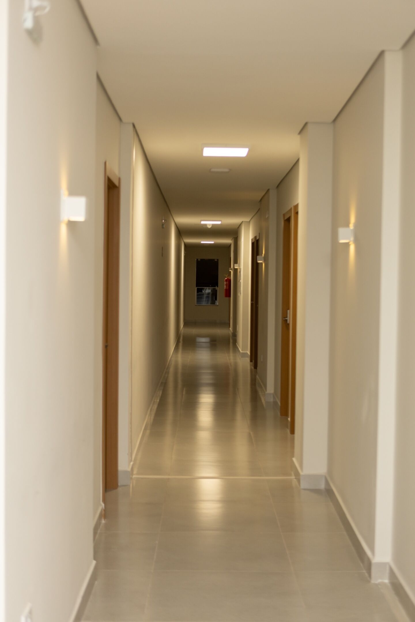 En lång, smal hall med dörrar på båda sidor, som leder in till rum.