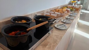 A buffet setup with various food items and cooking equipment. - Ex Hotels Laguna  (Inocência)