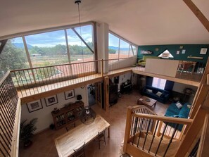 A spacious loft with a large balcony, a dining area, and a living room with a view of the countryside. - Guest house immersed in nature with horses and donkeys (Jouques)