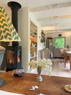 Ein gemütliches Interieur mit Kaminofen, Essbereich und Küche.