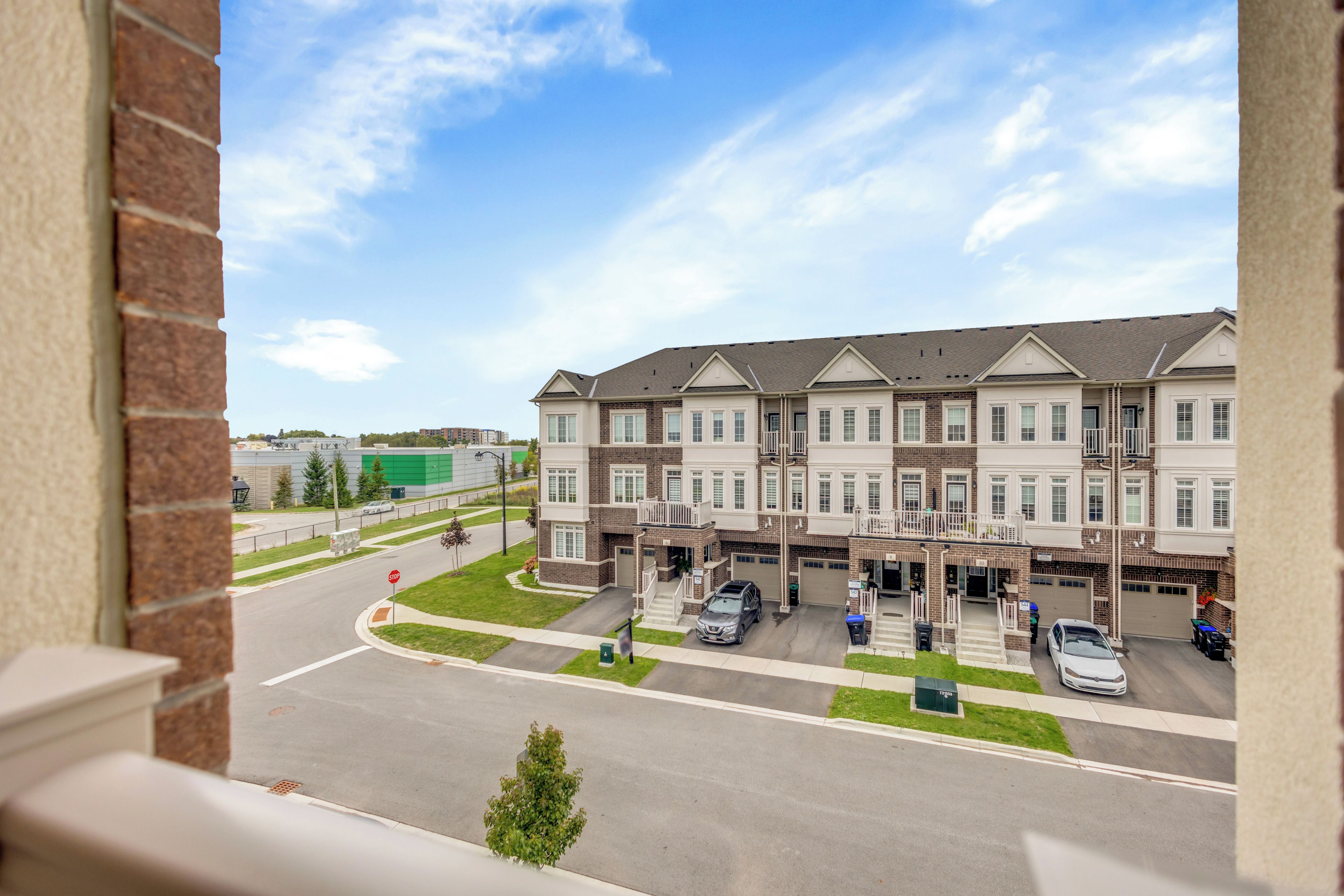 A multi-story residential building with a parking area in front.