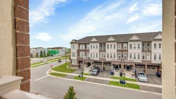 A multi-story residential building with a parking area in front.