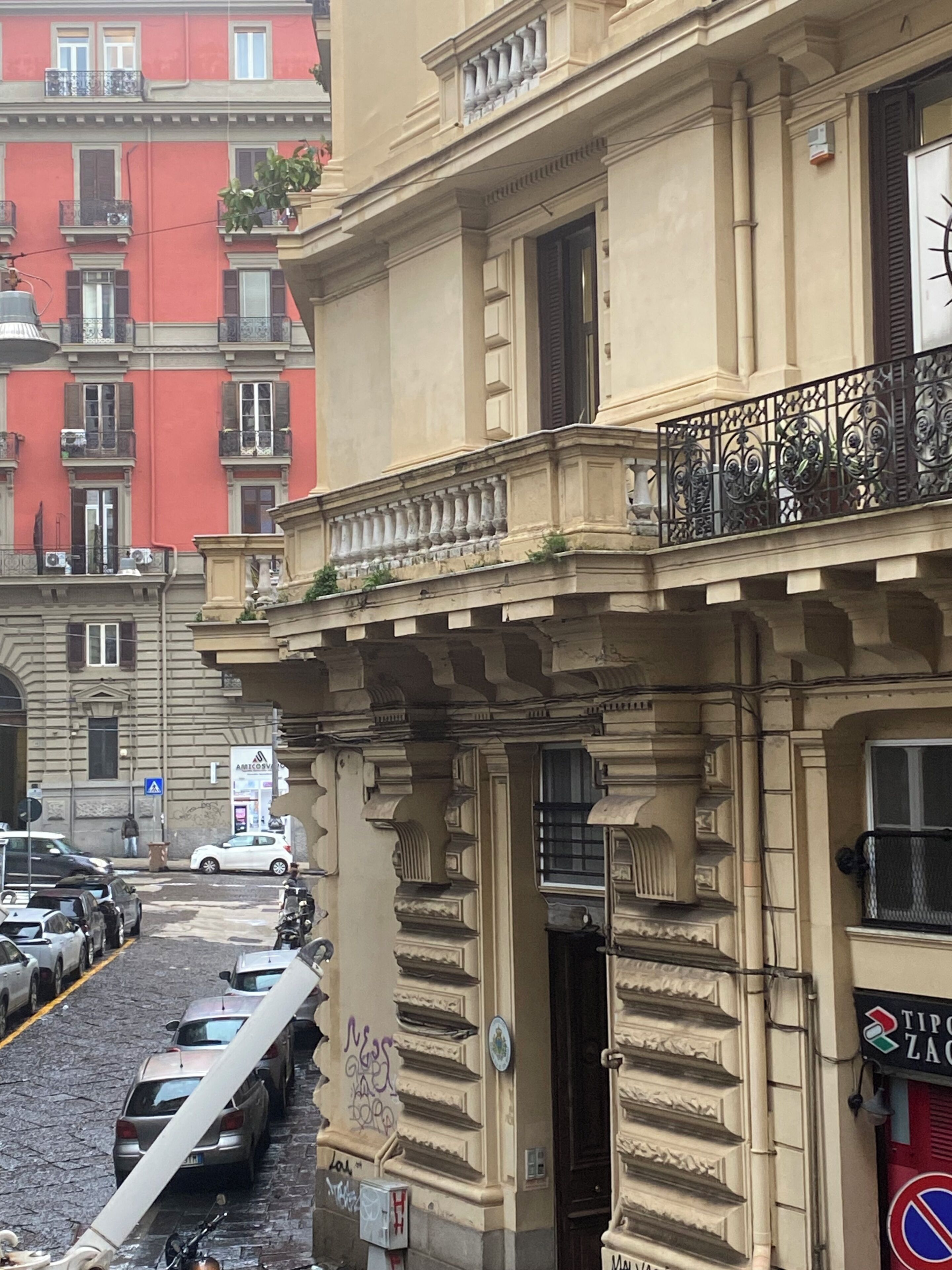 A building with a balcony, a door, and a sign with a logo.
