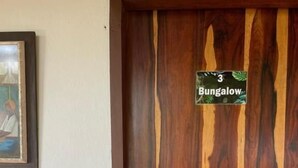 A wooden door with a sign that reads 'Bungalow' and a small number '3'.