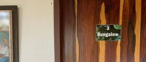 A wooden door with a sign that reads 'Bungalow' and a small number '3'.