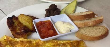 Two plates of food with toast, avocado, and sauces.