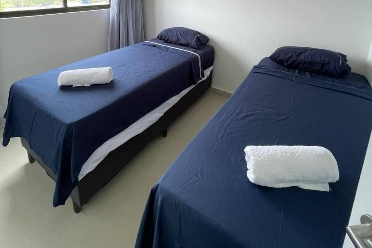 Una habitación con dos camas individuales, una ventana con vistas y una lámpara en el techo.