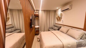 Habitación de hotel con dos camas, un armario, un espejo y un equipo de aire acondicionado.