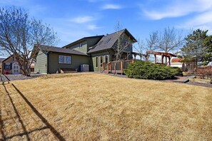 A two-story house with a green exterior, a covered porch, and a well-maintained lawn. - Ranch Studio Retreat with Mountain Views, Longmont, Colorado (Longmont)