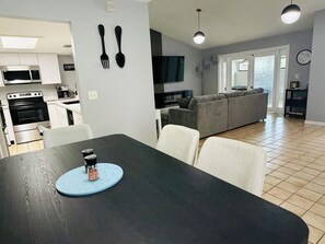Eine moderne Küche mit Esstisch, Stühlen und einer Kaffeemaschine.