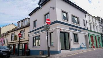 Un bâtiment sur lequel est apposée une pancarte « Interdit d’accès », un magasin appelé « Experience Dinges » et une voiture garée dans la rue.