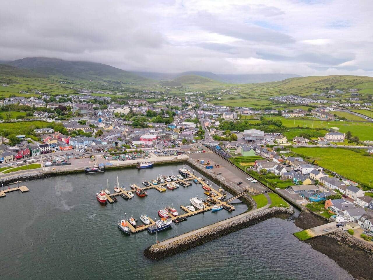 Une ville côtière dotée d’un port de plaisance, de maisons et de champs verdoyants.