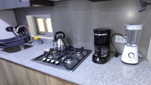 Eine Küche mit Gasherd, Wasserkocher, Kaffeemaschine und Mixer.