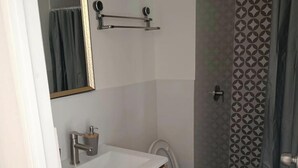 Ein Badezimmer mit Toilette, Waschbecken, Spiegel und Dusche.