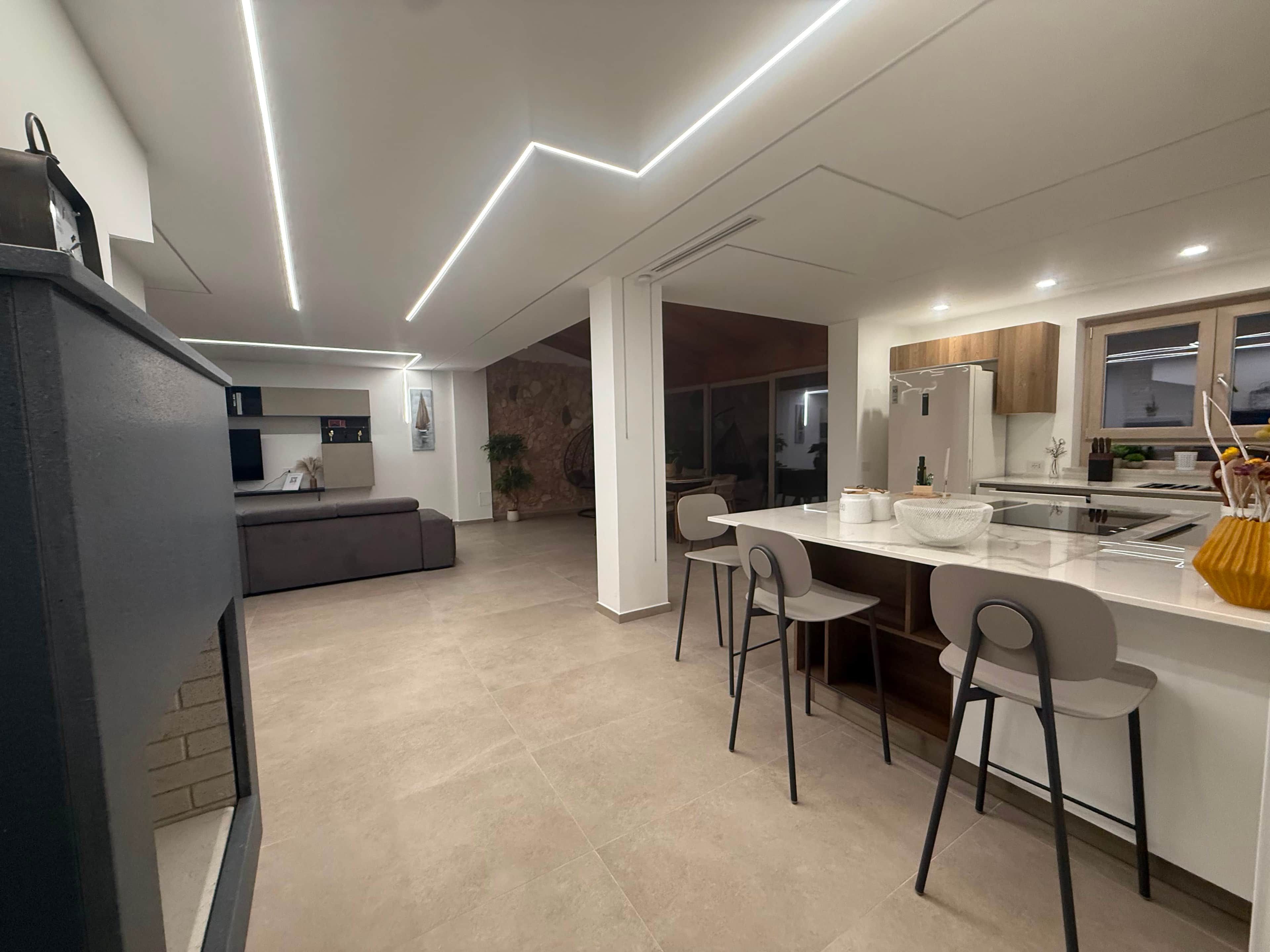 Une cuisine moderne dotée d’un îlot central, de tabourets de bar et d’un coin repas.
