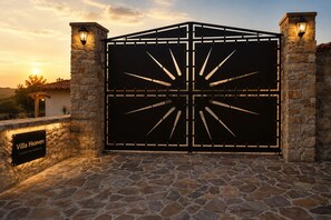 A gated entrance with a stone wall and a sign that reads 'Villa Heaven Exclusive Pool Experience.'