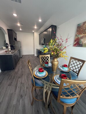 A modern kitchen with dark cabinets, a refrigerator, and a microwave.