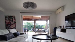 Een moderne woonkamer met een bank, een rond bijzettafeltje en een televisie.