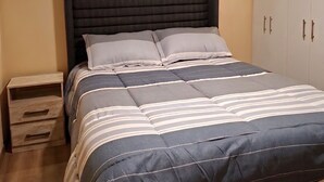 A bedroom with a bed, nightstands, and a wardrobe. - 3 bedroom apartment (Lima)