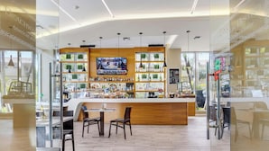 A modern bar area with a wooden counter, seating, and a TV screen. - Intracoastal Panorama- 2BR Beachwalk Resort (Hallandale Beach)