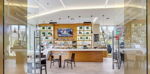 Eine moderne Bar mit Fernseher, Holztresen und Sitzgelegenheiten.