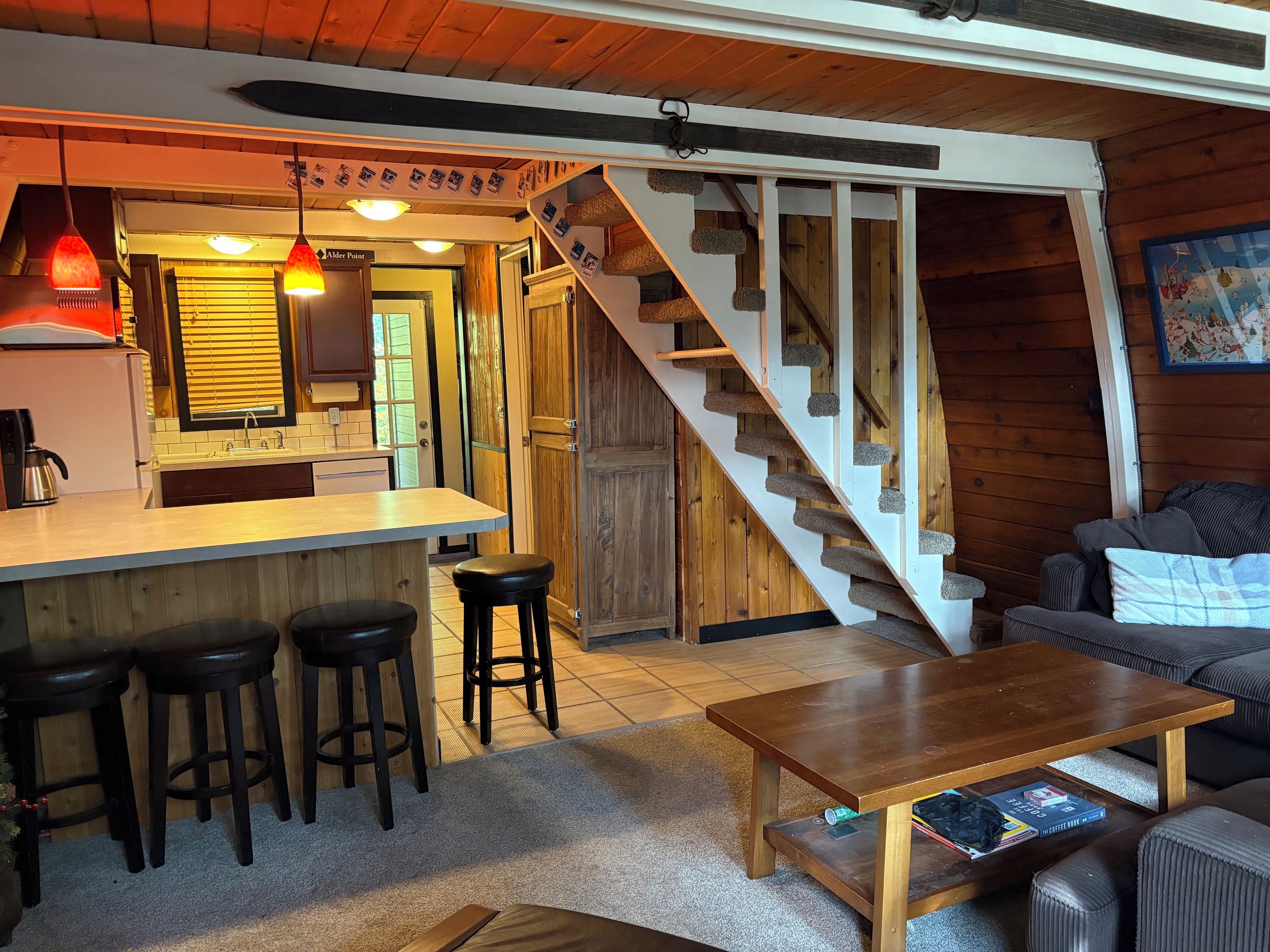 Ein gemütliches Interieur mit Küche, Bar und einer Treppe, die in eine andere Ebene führt.