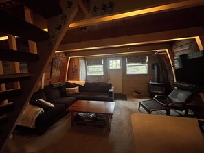 Ein gemütliches Wohnzimmer mit Sofa, Couchtisch und Kamin.