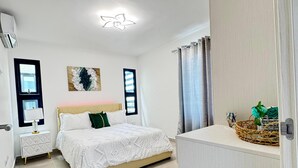 Ein Schlafzimmer mit Bett, Nachttischen, Deckenventilator und Kleiderschrank.