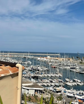 A marina filled with boats, a pier, and a distant view of the sea. - Seaview Downtown (Palermo)