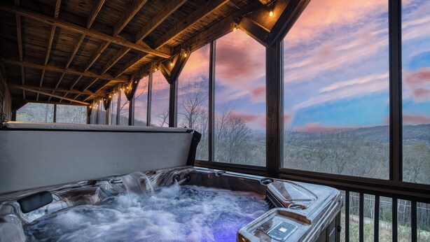 Ein Whirlpool mit Blick auf die Landschaft durch große Fenster.
