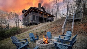 Eine Hütte mit Feuerstelle und Adirondack-Stühlen.