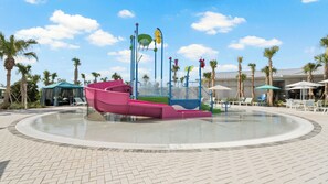 Ein Wasserpark mit einem großen runden Pool, Rutschen und einem Spielbereich.