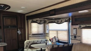 Un intérieur de camping-car confortable, avec un canapé, un coin repas et une petite cuisine.