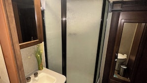 Une salle de bain avec une douche, un lavabo et des toilettes.