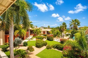 A resort with a pool, palm trees, and a clear blue sky. - Sea View Apartment, Infinity Pool & Beach, 5 min Jan Thiel | B7 (Willemstad)