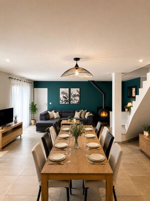 Ein modernes Wohnzimmer mit Essbereich, Kamin und Treppe.