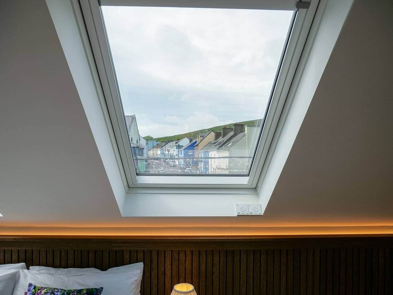 A skylight in a room with a view of buildings and a street.