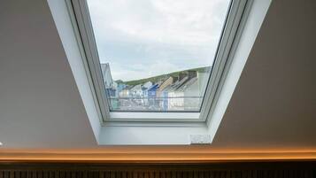 A skylight in a room with a view of buildings and a street.