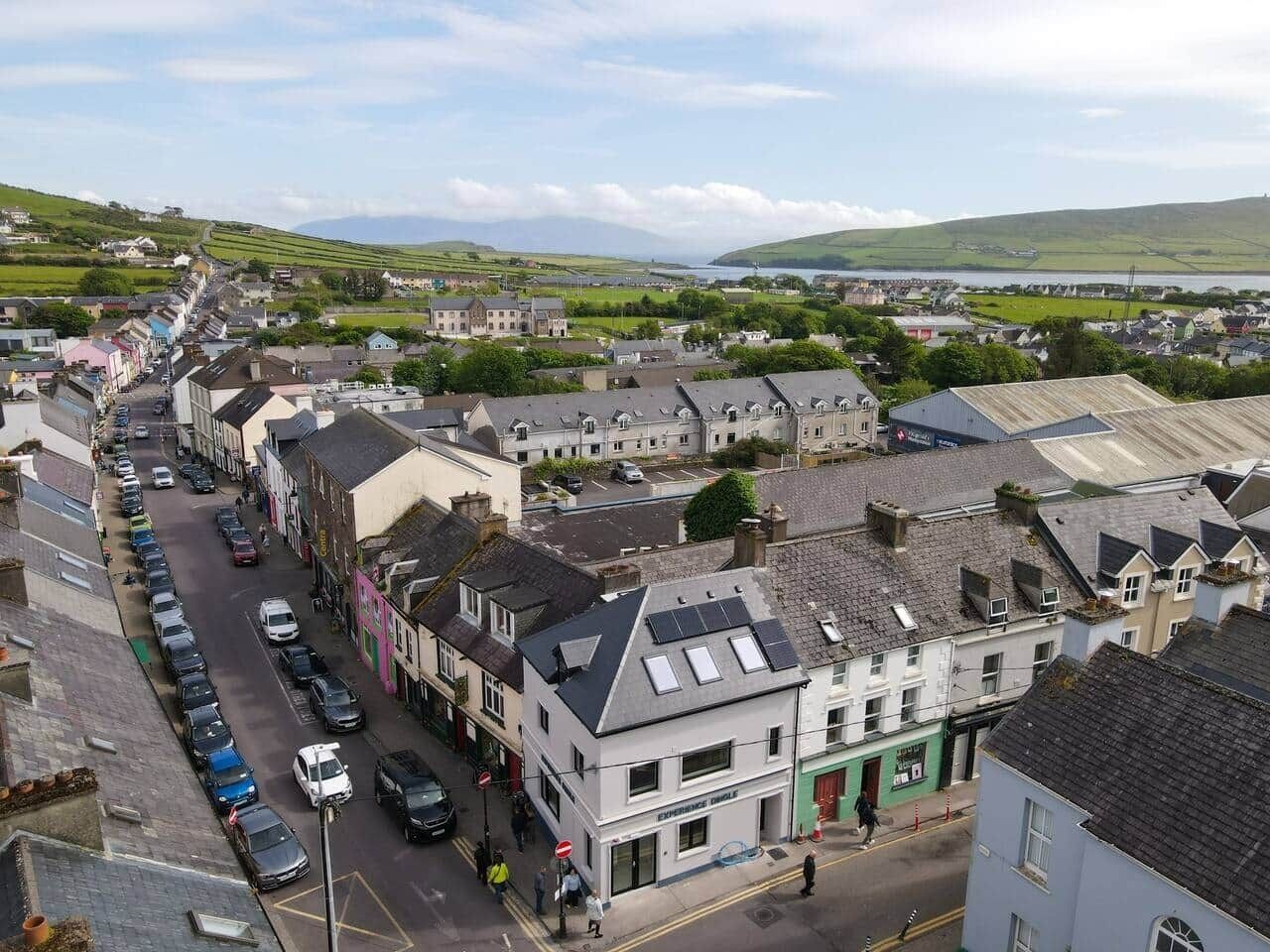 A town with a main street lined with buildings, including a shop with a green awning.