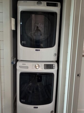 Deux sèche-linge Maytag sont empilés dans une buanderie blanche.