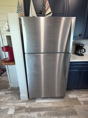 A stainless steel refrigerator in a kitchen with a coffee maker and a kettle on the counter. - Relax on the Bay-Stunning Sunsets & the Perfect Coastal Getaway (Port St. Joe)