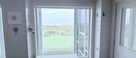 Una habitación con un banco, una cesta y vistas al exterior.