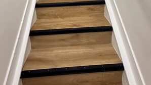 Un escalier avec des marches en bois et des rampes blanches.