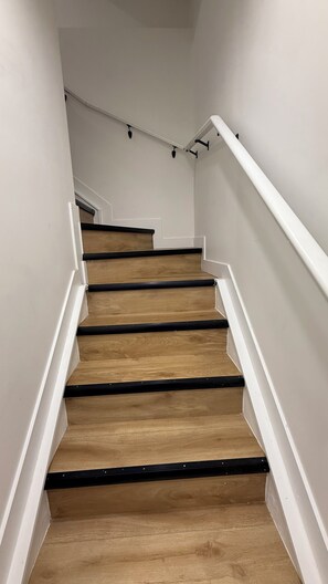 A staircase with wooden steps and white handrails. - Our Cozy Corner (Edmonton)