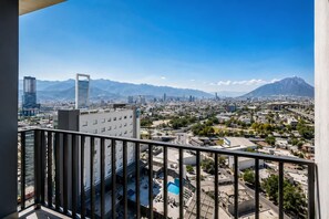 A cityscape with a mountain range in the background, a clear sky, and a view from a balcony with a pool and outdoor seating. - Refugio Tranquilo/Ac/4px/Parking (Monterrey)
