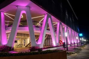 Ein modernes Gebäude mit einem einzigartigen architektonischen Design und großen, beleuchteten Buchstaben.